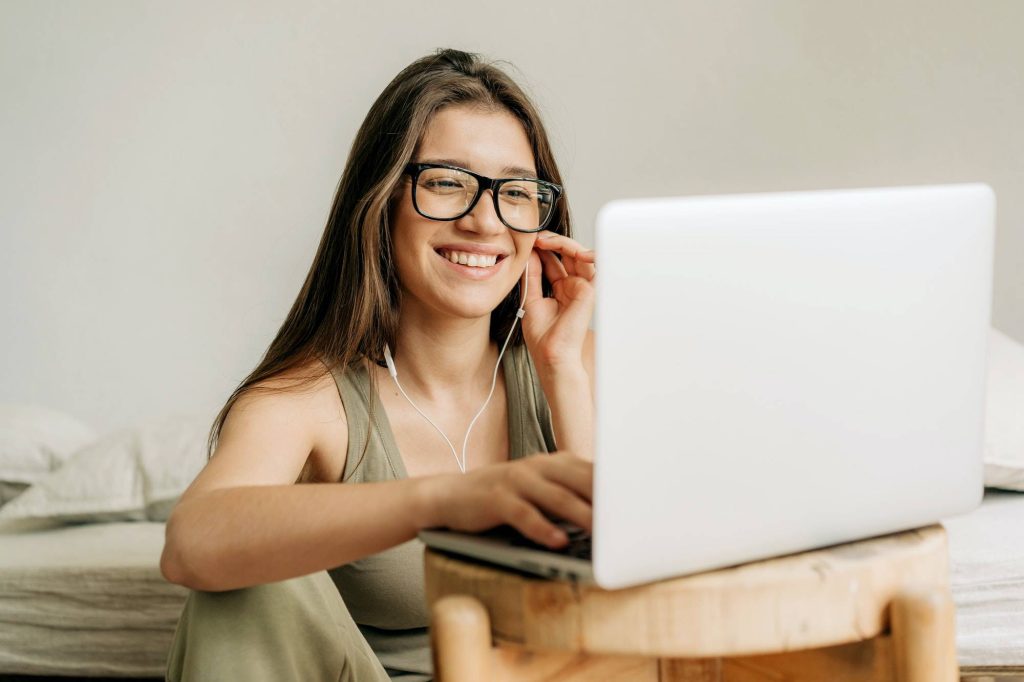 Mujer independiente en una reunión en línea usando laptop y auriculares.